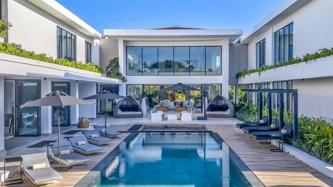 Elegant outdoor pool at Yarari Royale with sleek loungers, daybeds, and contemporary minimalist architecture in Cap Cana.