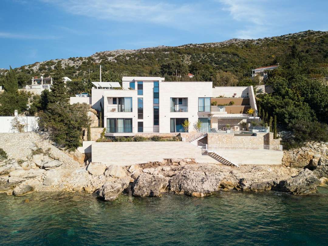Elegant modern stone villa in Zaton featuring a private seafront setting, expansive terraces, and direct access to the sea.